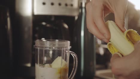 Person-Making-Banana-Smoothie-With-Milk-In-The-Blender-For-Breakfast