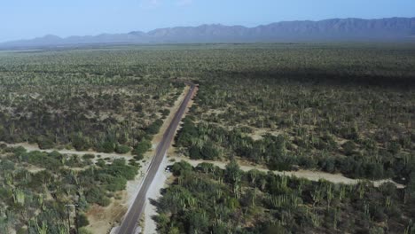 Aerial-shot-of-a-desert-road-and-a-mountain-range-in-Baja,-Mexico