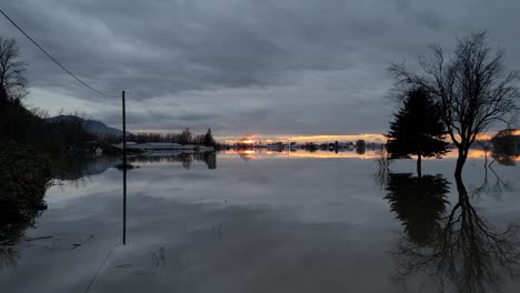 Motion-sideways-of-flooding-in-Abbotsford-during-sunset-with-reflection-on-water-surface