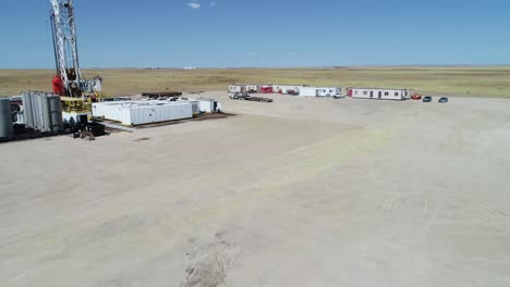 Drone-flight-over-a-fracking-pad-focusing-on-a-semi-truck-and-working-coming-out-of-a-trailer