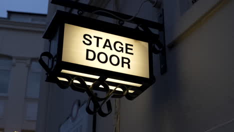 Stage-door-sign-lit-up-at-night-outside-a-theatre
