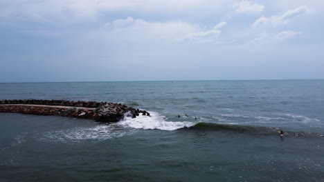 Unrecognizable-surfers-enjoying-waves-in-Vietnam-Sea