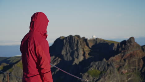 Man-in-windbreaker-looks-out-over-rugged-volcanic-mountains-on-Madeira-Portugal