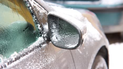 Close-Up-Of-Right-Side-Mirror-Of-A-Parked-Car-With-Snow-Defrosting