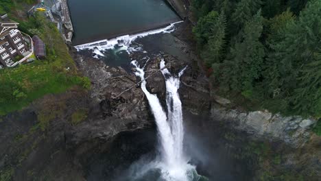 Aerial-pulling-away-from-Snoqualmie-Falls-to-reveal-a-dense-forest-and-visitors-lodge