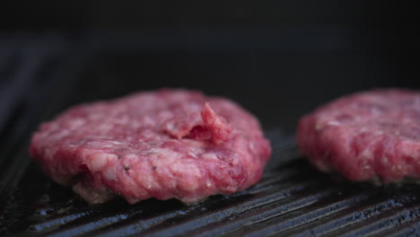 Stationary-extreme-close-up-of-burger-patties-sizzling-on-a-BBQ