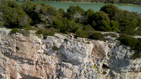 Women-standing-on-top-of-cliff-edge,-National-Park-Kornati,-Croatia