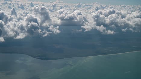 Viewing-the-clouds-and-coast-of-Cancun-Mexico-from-an-airplane,-aerial
