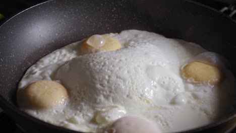 Opening-Lid-Of-A-Frying-Pan-With-Fresh-Sunny-Side-Up-Eggs-Cooking