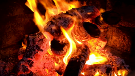 Close-up-shot-of-dancing-flames-of-campfire,-red-hot-coals