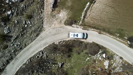 Top-down-aerial-view-of-RV-driving-a-curve-road,-Park-Prirode-Biokovo,-Croatia