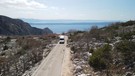 Lone-camper,-RV-driving-mountain-road-against-Adriatic-Sea-and-Islands