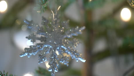 Shinning-silver-snowflake-hanging-on-Christmas-tree,-close-up-view