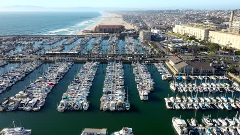 Drone-shot-flying-over-a-yacht-marina-and-beach-in-California,-America