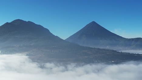 Vista-Aérea-De-Drones-De-Dos-Volcanes-Por-Encima-De-La-Línea-De-Nubes