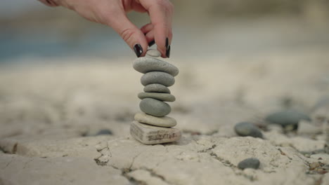 Small-stone-formation-girl-hand-on-beach