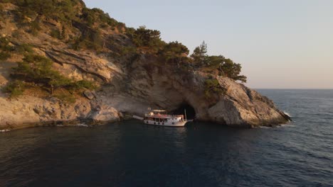 Aerial-footage-oludeniz-turkey-tourist-destination,-luxury-boat-in-natural-reserve-coastline-rock-cliff-formation
