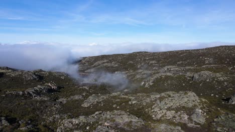Aerial-view-orbiting-around-a-small-cloud-path-in-the-top-of-the-mountain-at-Serra-da-Estrela-Portugal