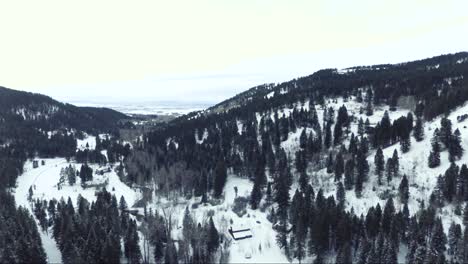 AERIAL---snowy-forest-with-isolated-building