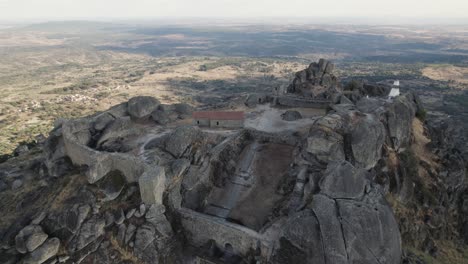 Wide-aerial-view-picturesque-castle-on-hilltop,-Monsanto-Rocky-Landscape