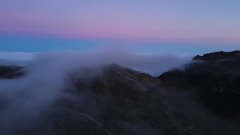 Aerial-view-of-a-beautiful-foggy-mountain-valley-after-sunset