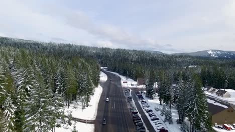 Aerial-following-a-highway-to-a-snow-covered-ski-resort