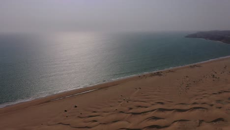 Aerial-View-Of-Arabian-Sea-With-Tilt-Down-View-Of-Desert-Sand-Dunes-Beside-It-In-Balochistan