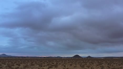 Die-Mojave-Wüstenlandschaft-Bei-Sonnenaufgang-Oder-Sonnenuntergang-An-Einem-Bewölkten-Tag---Verschiebbare-Luftaufnahme-Des-Zerklüfteten-Geländes