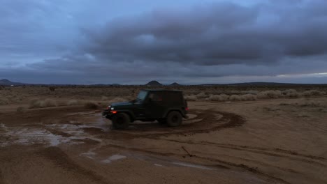 Spinning-a-donut-with-a-jeep-in-the-mud-in-the-Mojave-Desert-after-a-cloudburst---aerial-view