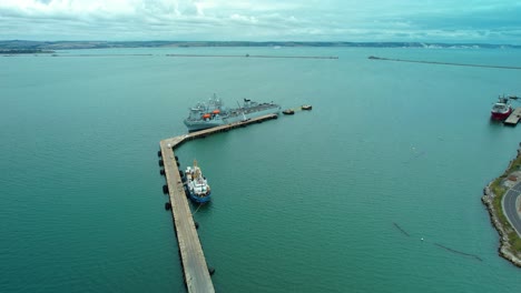 Aerial-view-over-Argus-Royal-fleet-auxiliary-British-military-floating-hospital-ship-docked-at-harbour-breakwater
