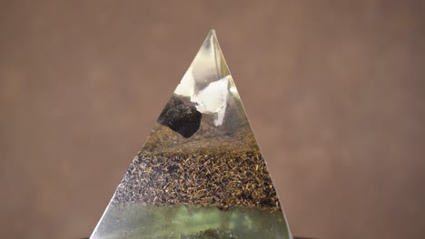 Orgonit-Kristallpyramide,-Die-Sich-Vor-Bokeh-Hintergrund-Dreht