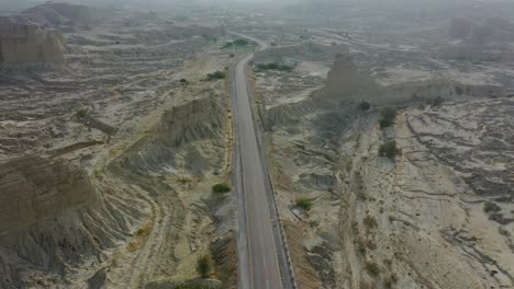 Vista-Aérea-De-La-Carretera-Vacía-A-Través-Del-Accidentado-Paisaje-árido-Del-Desierto-De-Baluchistán