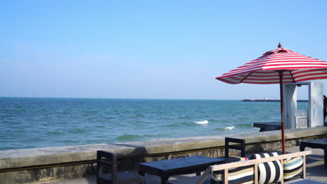 empty-bench-sofa-with-umbrella-and-ocean-sea-background---holiday-and-vacation-concept
