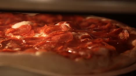 Pepperoni-baking-in-the-oven-with-the-cheese-and-oils-sizzling-in-the-heat---close-up-sliding-view