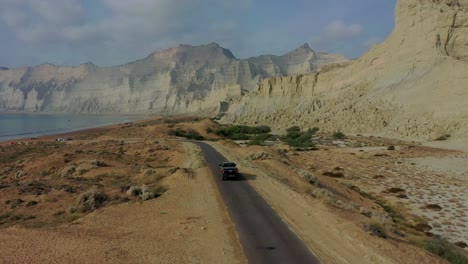 Aerial-View-Of-4x4-Truck-Driving-Along-Road-Beside-Coastline-In-Balochistan
