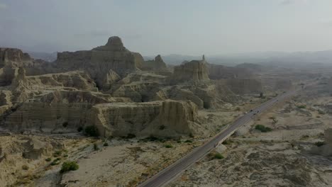 Vista-Aérea-De-La-Carretera-Vacía-A-Través-Del-árido-Paisaje-Montañoso-Del-Parque-Nacional-Hingol-En-Baluchistán