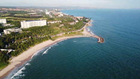 Resorts-De-Lujo-Construidos-En-La-Costa-Tropical-En-El-Sur-De-Vietnam,-Mientras-Que-Las-Olas-Se-Agitan-Pacíficamente-En-La-Playa-De-Arena-En-Mui-Ne-Vietnam