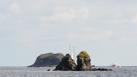 Sailboat-sailing-in-between-two-large-rocky-cliff-islands-near-Manuel-Antonio-national-Park-in-Costa-Rica