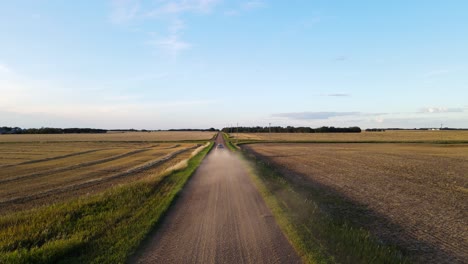 Drone-hovering-low-above-a-red-dirt-road-in-rural-countryside-setting