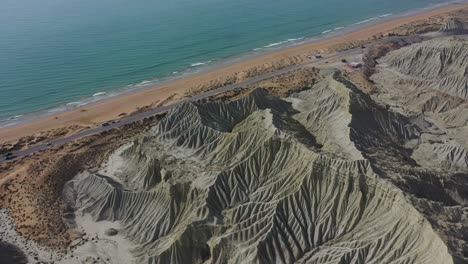 Aerial-View-Of-Rugged-Coastline-Beside-Beach-And-Arabia-Sea-At-Balochistan