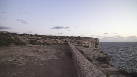 Zu-Fuß-Auf-Dem-Plateau-In-Richtung-Felsiger-Hügel-In-Der-Nähe-Des-Mittelmeers-In-Malta-An-Einem-Sonnigen-Abend-In-Lila-Farbe