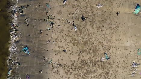 Aerial-top-down,-polluted-beach-with-plastic-trash-on-shore