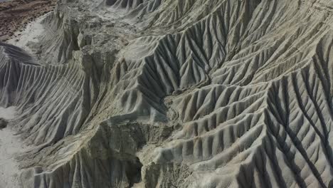 Antena-Sobre-Formaciones-Rocosas-Geológicas-Desgastadas-Con-Inclinación-Hacia-Arriba-Revelan-El-Mar-Arábigo-Y-La-Playa-En-Baluchistán