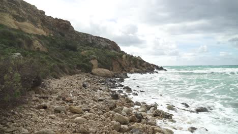 Caminar-Sobre-Rocas-Cerca-De-La-Playa-De-Golden-Bay-En-Invierno-En-Malta-En-Un-Día-Soleado-Y-Ventoso