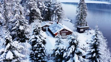 Winter-Landscape-Of-Forest,-Cabin,-And-Frozen-Lake-In-Norway