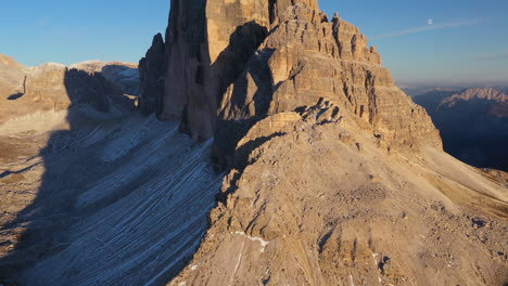 Tilting-up-cinematic-drone-shot-of-Tre-Cime-di-Lavaredo-in-Italy,-showing-the-peaks-Cima-Piccola,-Cima-Grande-and-Cima-Ovest