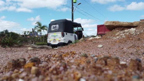 Truck-and-tuk-tuk-driving-on-a-dirt-road