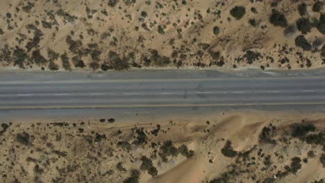 Antena-Mirando-Hacia-Abajo-En-Una-Carretera-Vacía-A-Través-Del-Paisaje-Desértico-En-Baluchistán