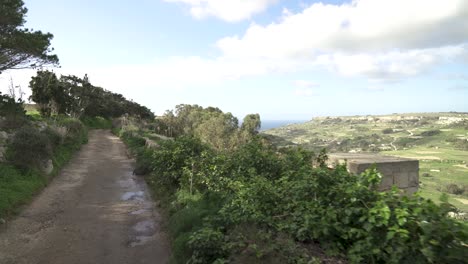 Caminando-Por-Una-Carretera-De-Alta-Montaña-En-Malta-Cerca-De-Tierras-De-Cultivo-En-El-Cañón