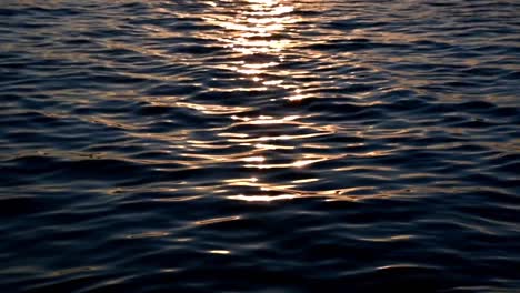 Ripple-blue-water-in-the-ocean-during-sunset,-liquid-waves-in-the-sea-reflecting-the-sun,-nature-background